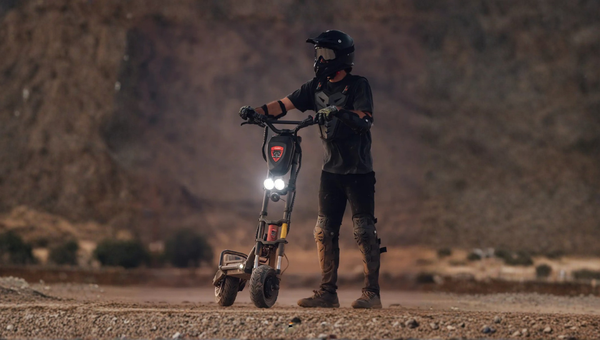 Person on a off road 50 mph electric scooter in a desert setting