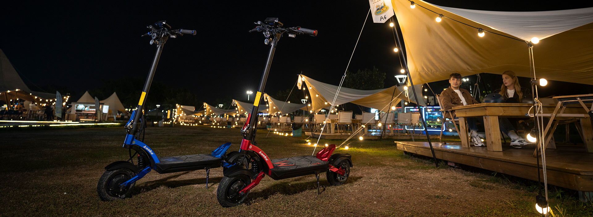 Kaabo electric scooters parked at a vibrant outdoor evening event, highlighting the social and portable lifestyle with electric mobility.