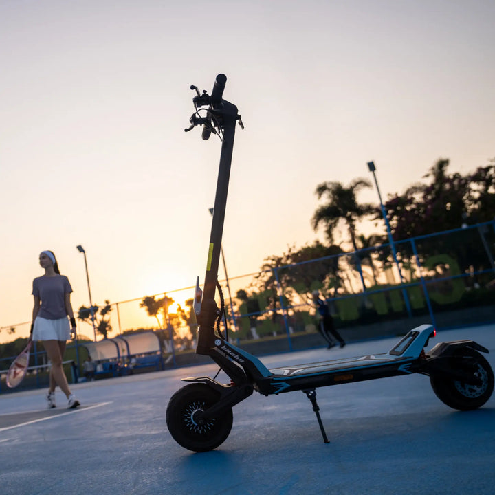 Kaabo Urban commuter electric scooter parked on an outdoor court at sunset