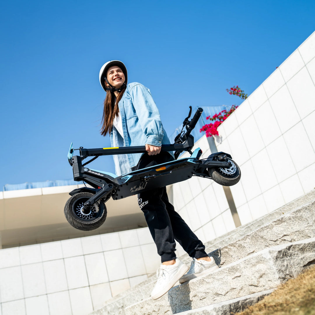 Woman carrying Kaabo Urban compact electric scooter on stairs for commuting