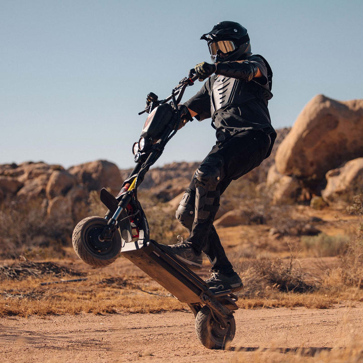 Adventurous off-road wheelie performed on the rugged Kaabo Warrior 11 Pro+ electric scooter, showcasing its powerful dual-motor capabilities and robust construction.