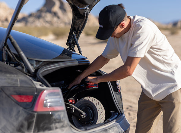 A folded Kaabo Wolf Warrior 11 Pro+ electric scooter fitting neatly into the trunk of a car, illustrating its portability and ease of storage.