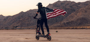 a man wearing a US national flag riding Kaabo Wolf Warrior 11 scooter